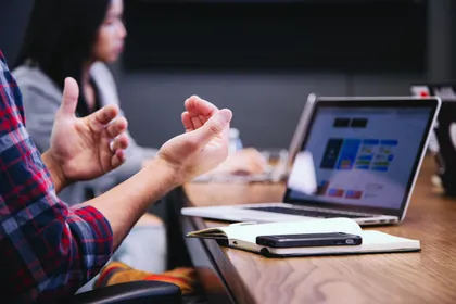 Hands gesturing during a working discussion at a laptop